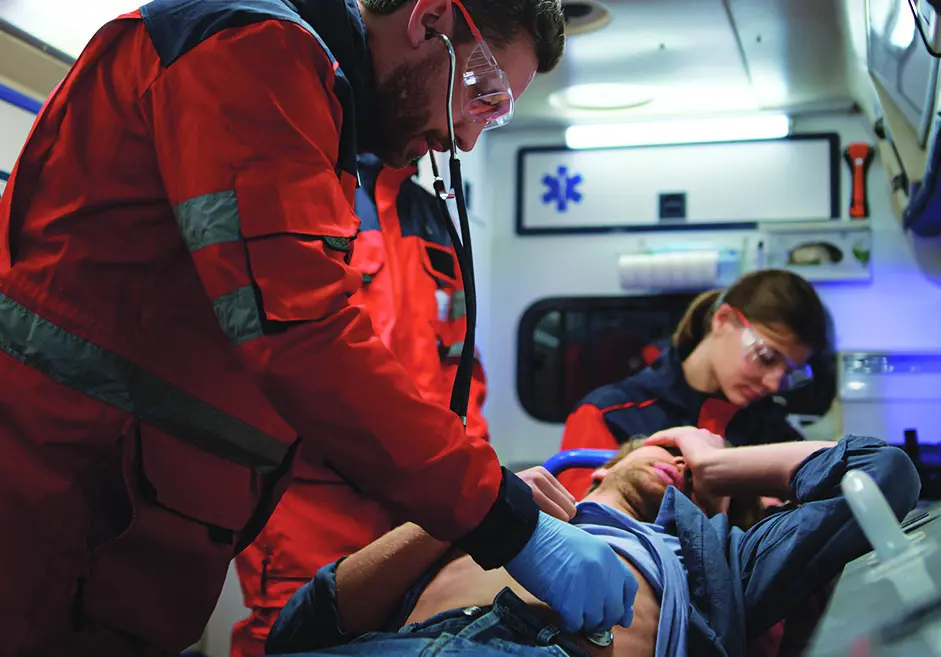 Emergency responders delivering care inside an ambulance